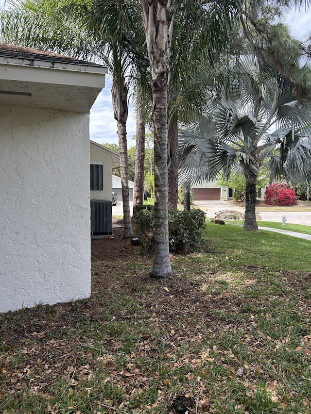 view of yard with a garage and central air condition unit