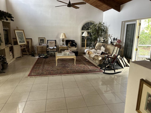living area with high vaulted ceiling, ceiling fan, wood ceiling, tile patterned floors, and beam ceiling