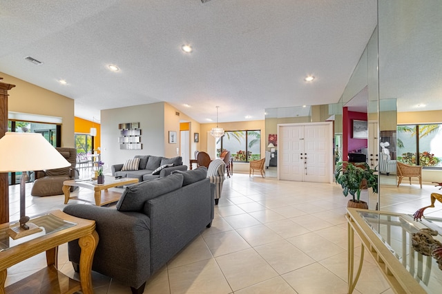 living area featuring plenty of natural light, light tile patterned floors, visible vents, and a textured ceiling