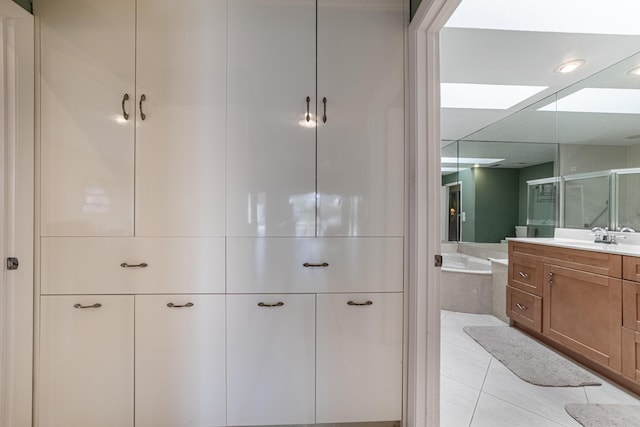 bathroom with a shower stall, tile patterned floors, vanity, and a bath