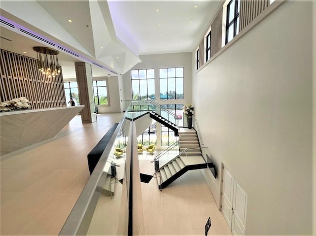 stairs with recessed lighting, an inviting chandelier, and a towering ceiling
