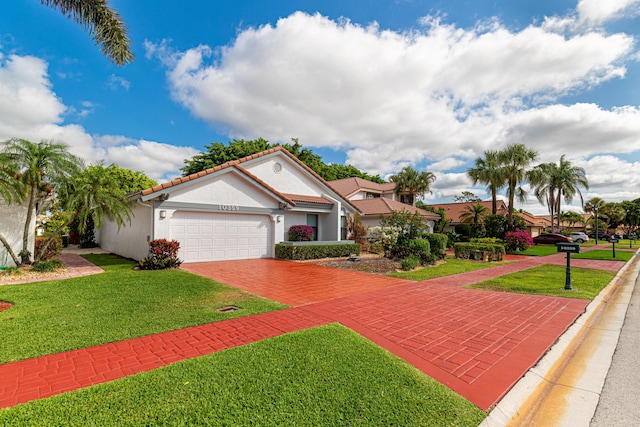 view of front of property with stucco siding, decorative driveway, a front lawn, a tile roof, and a garage