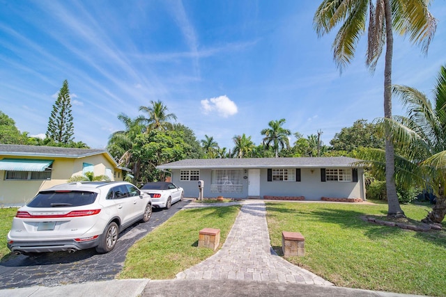 941 NW 26th Ct, Wilton Manors, FL 33311 - ranch-style home with aphalt driveway and a front lawn