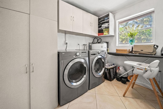 941 NW 26th Ct, Wilton Manors, FL 33311 - clothes washing area with cabinet space, light tile patterned floors, and washing machine and dryer