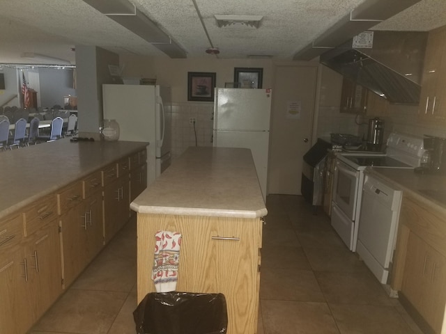 7 Lake Vista Trl Unit 204, Port Saint Lucie, FL 34952 - kitchen with white appliances, light tile patterned flooring, a kitchen island, and light countertops