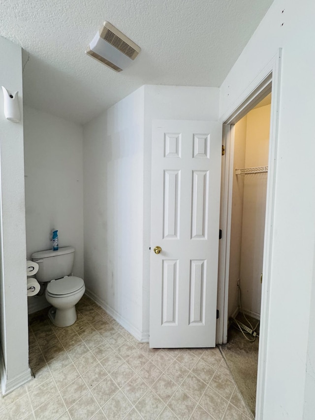 5155 NW N Macedo Blvd, Port Saint Lucie, FL 34983 - bathroom featuring toilet, a textured ceiling, and tile patterned flooring
