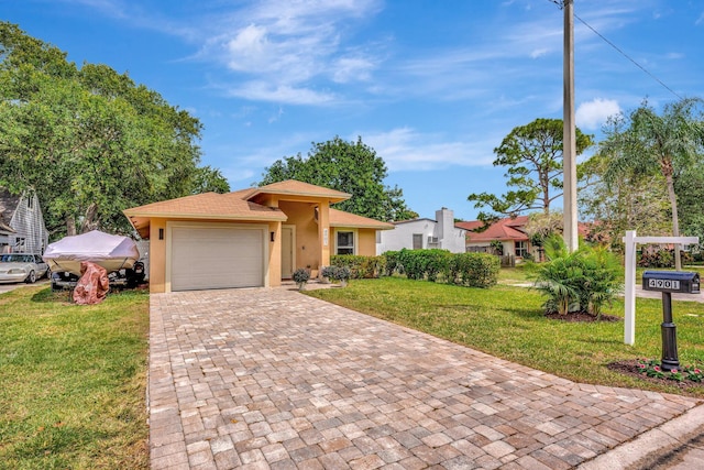 view of front of home with a front yard, decorative driveway, a garage, and stucco siding