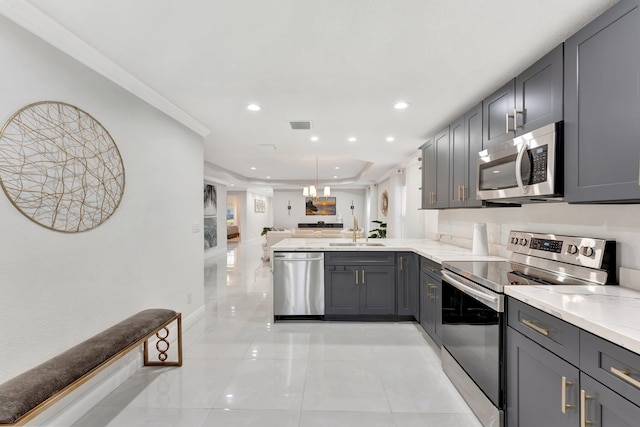 kitchen featuring light tile patterned floors, a sink, open floor plan, appliances with stainless steel finishes, and gray cabinets