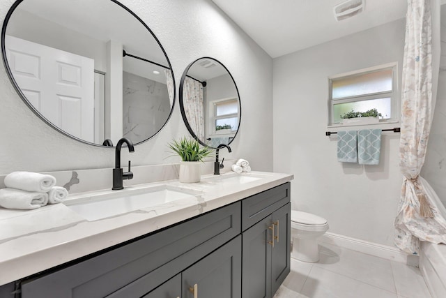 full bathroom featuring toilet, double vanity, a sink, and visible vents