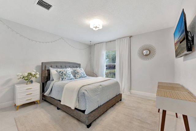 bedroom with visible vents, baseboards, and a textured ceiling