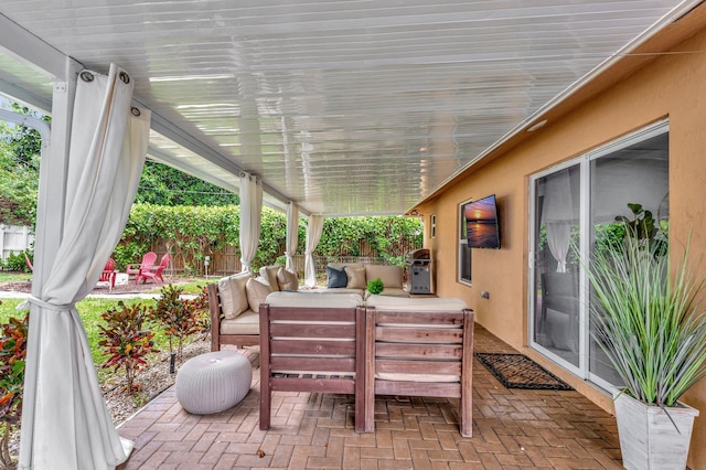 view of patio featuring an outdoor living space, fence, and a grill