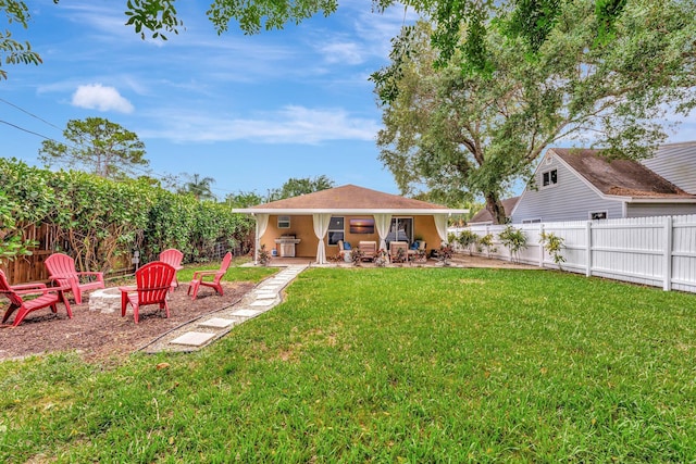 back of property featuring stucco siding, a fire pit, a patio area, a fenced backyard, and a lawn