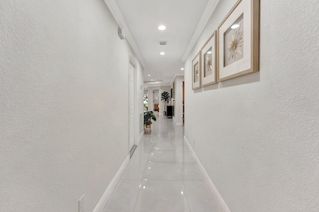 hallway featuring baseboards, recessed lighting, light tile patterned floors, crown molding, and visible vents