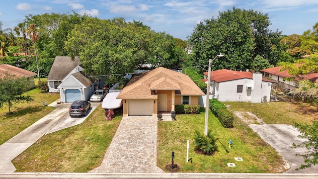 view of front of home with a garage, fence, stucco siding, a front lawn, and driveway