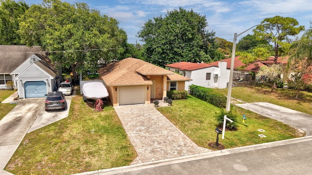 view of front facade featuring stucco siding, a front yard, an attached garage, a shingled roof, and driveway
