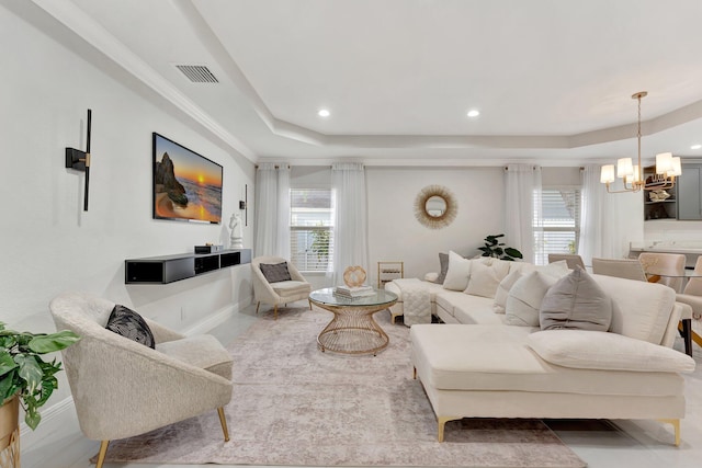 living room with visible vents, recessed lighting, a raised ceiling, a notable chandelier, and baseboards