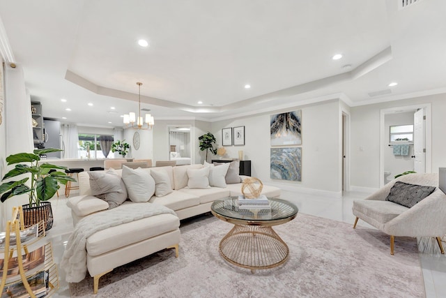 living area with a tray ceiling, recessed lighting, and an inviting chandelier