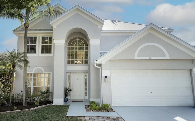 view of front of property with an attached garage, driveway, and stucco siding