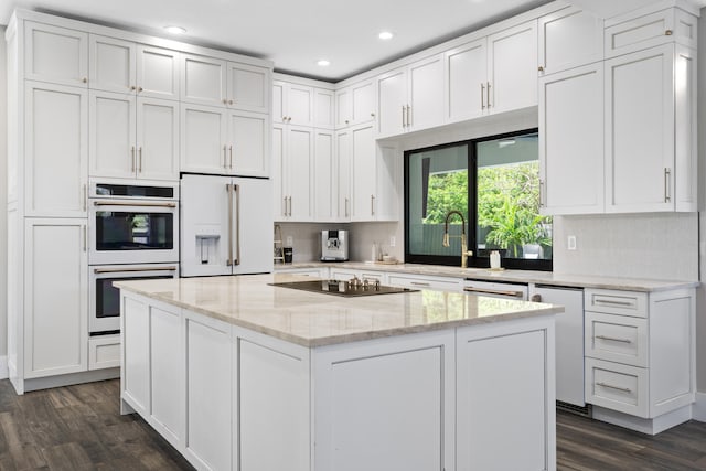 1784 SW Erie St, Port Saint Lucie, FL 34953 - kitchen with white appliances, a kitchen island, dark wood-style floors, and white cabinetry