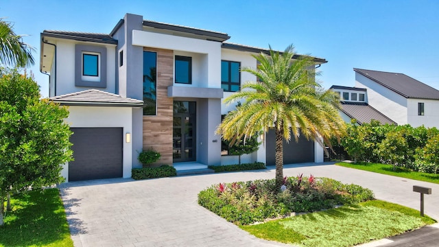 660 NE 29th Pl, Boca Raton, FL 33431 - contemporary home featuring decorative driveway, stucco siding, a garage, and a tiled roof