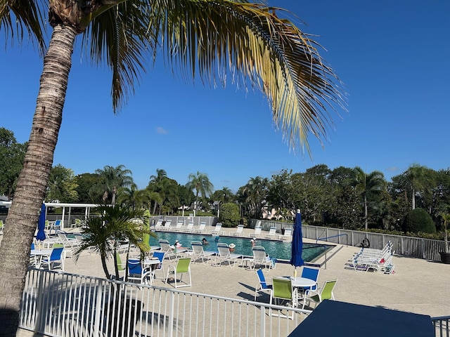 9872 SE Little Club Way S, Tequesta, FL 33469 - community pool featuring a patio and view of wooded area