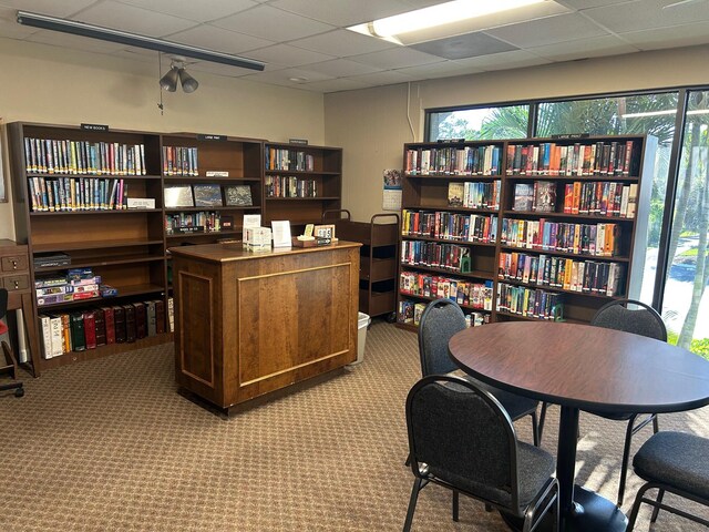 9872 SE Little Club Way S, Tequesta, FL 33469 - carpeted home office featuring a paneled ceiling, wall of books, and ceiling fan