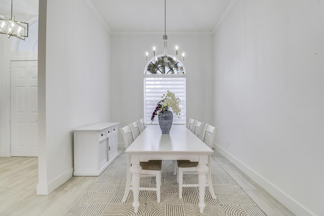 unfurnished dining area featuring light wood-type flooring, a notable chandelier, baseboards, and ornamental molding