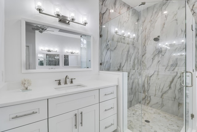 bathroom with a marble finish shower, a ceiling fan, and vanity