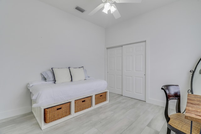 bedroom with visible vents, baseboards, light wood-type flooring, and a closet