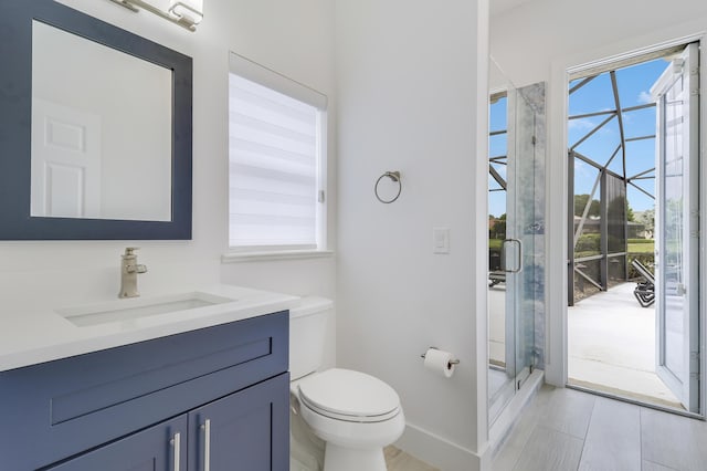 full bath with a shower stall, vanity, baseboards, and toilet