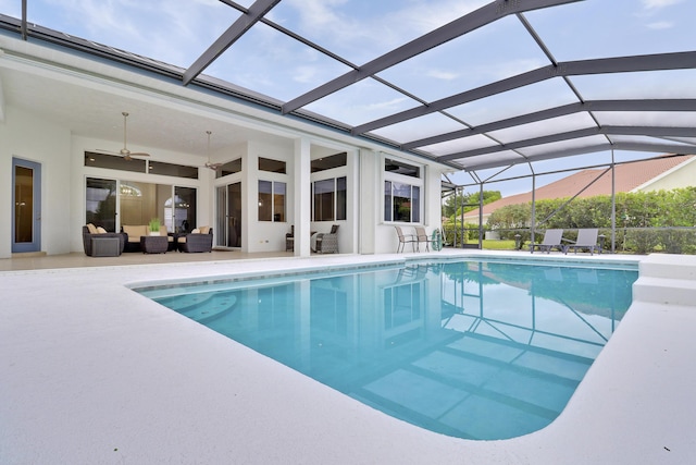 outdoor pool featuring outdoor lounge area, a patio area, a ceiling fan, and glass enclosure