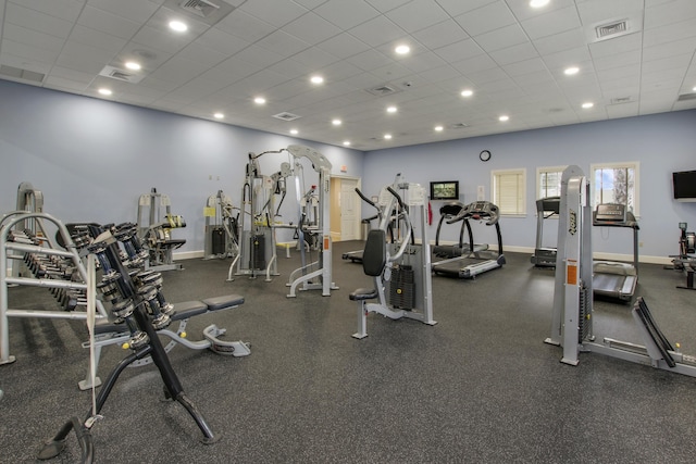 exercise room featuring visible vents, baseboards, and a paneled ceiling