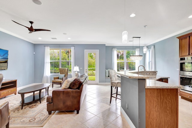 living room featuring crown molding, a ceiling fan, and recessed lighting