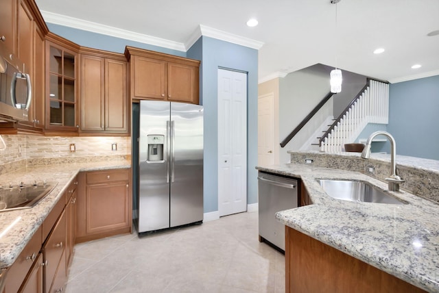 kitchen featuring a sink, appliances with stainless steel finishes, crown molding, and brown cabinets