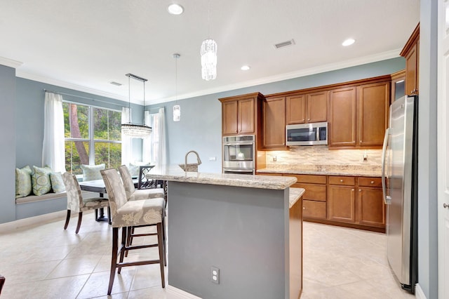 kitchen featuring light stone countertops, decorative backsplash, brown cabinetry, and appliances with stainless steel finishes