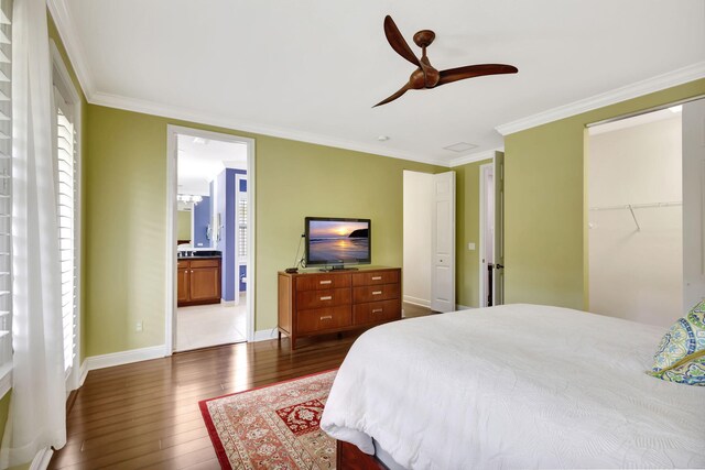 bedroom with a closet, baseboards, crown molding, a ceiling fan, and dark wood-type flooring