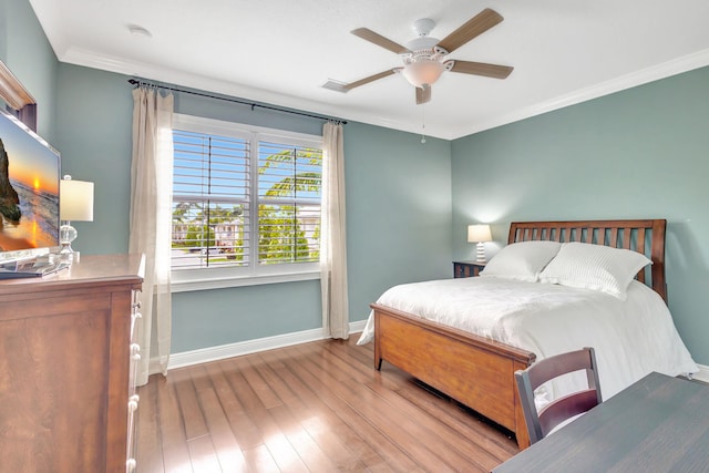 bedroom featuring ornamental molding, baseboards, ceiling fan, and wood finished floors