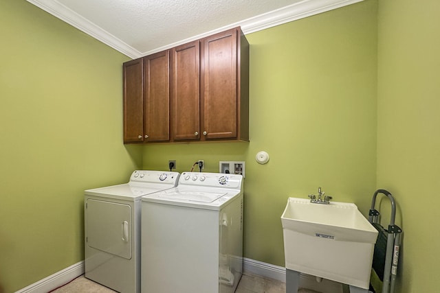 laundry area with ornamental molding, a sink, washer and dryer, baseboards, and cabinet space