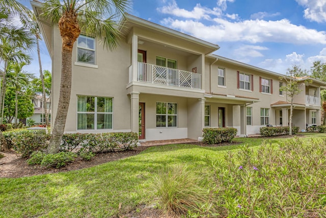 view of front of house with stucco siding and a front lawn