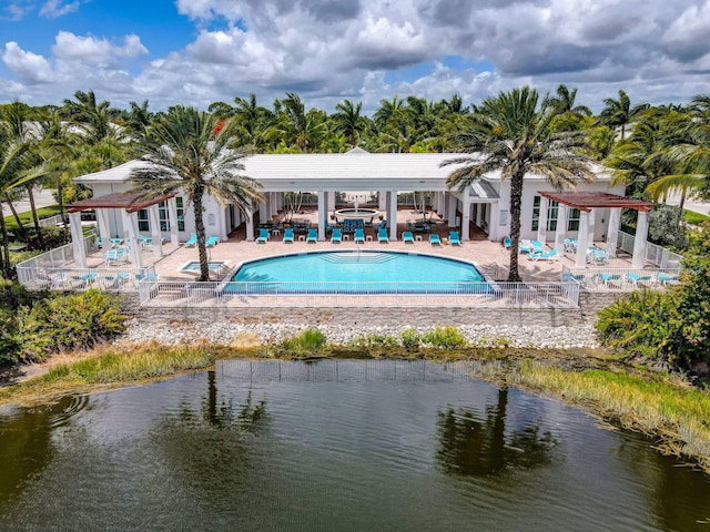 community pool featuring a jacuzzi, a patio area, and fence