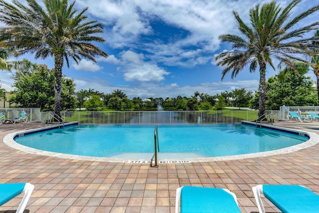 community pool featuring a patio area and fence
