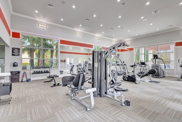 gym with visible vents, crown molding, and carpet floors