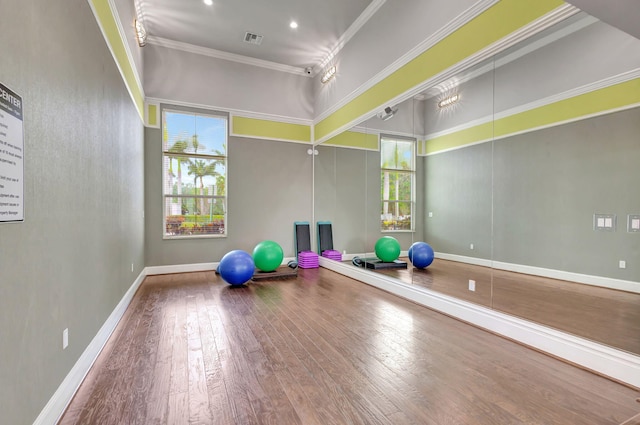 workout area with plenty of natural light, visible vents, ornamental molding, and wood finished floors