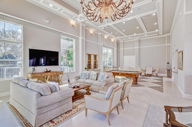 living room featuring a chandelier, light tile patterned flooring, a towering ceiling, and baseboards