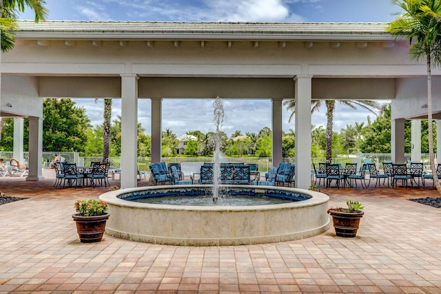view of community with outdoor dining space, a patio, and fence