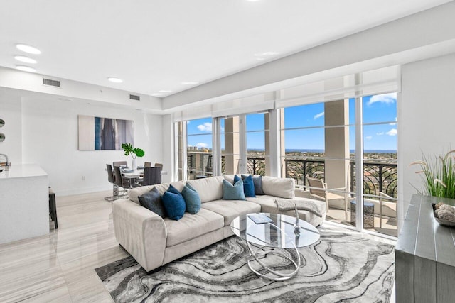 living room with recessed lighting, visible vents, and baseboards