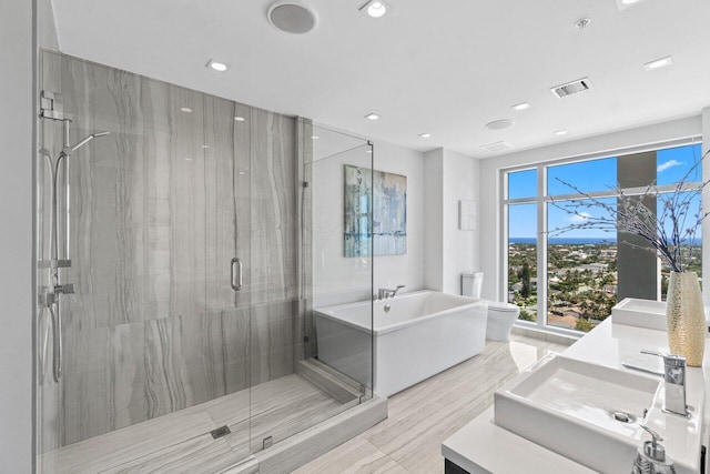 full bathroom with a soaking tub, a marble finish shower, visible vents, recessed lighting, and vanity