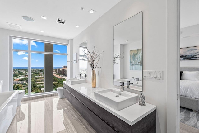 ensuite bathroom with ensuite bathroom, visible vents, a sink, and double vanity