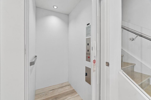 interior space with elevator, wood finished floors, and recessed lighting