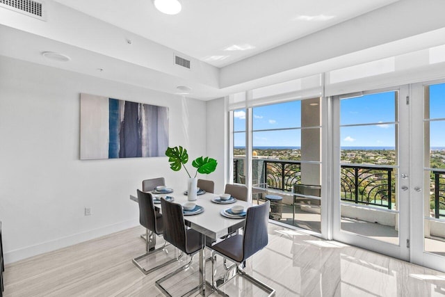 dining area featuring baseboards, visible vents, and plenty of natural light